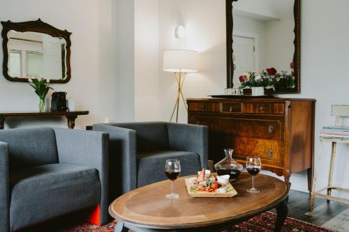 a living room with two chairs and a table with wine glasses at The Kent Motel in Niagara on the Lake