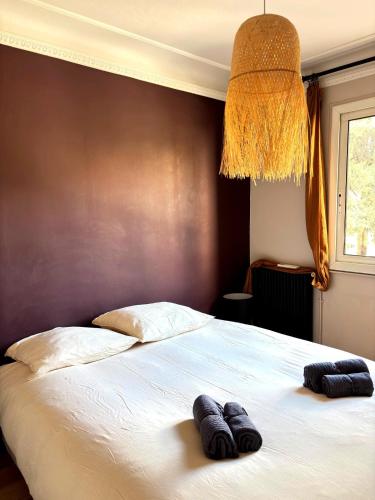 une chambre avec un lit avec deux pantoufles dessus dans l'établissement Paul Cézanne garden apartment with air conditioning, à Aix-en-Provence