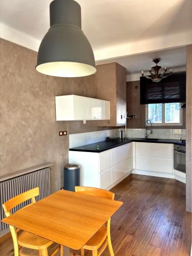 Il comprend une cuisine avec une table et des chaises en bois. dans l'établissement Paul Cézanne garden apartment with air conditioning, à Aix-en-Provence