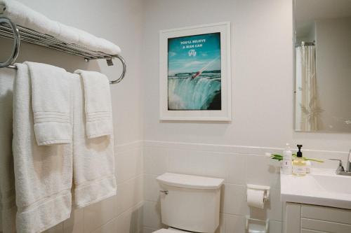 a bathroom with a toilet and a picture on the wall at The Kent Motel in Niagara on the Lake