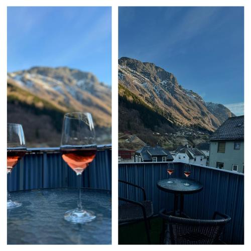 a glass of wine sitting on a table on a balcony at StarApartment Trolltunga 2 BR in Odda