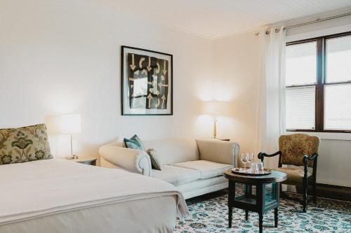 a bedroom with a bed and a couch and a table at The Kent Motel in Niagara on the Lake