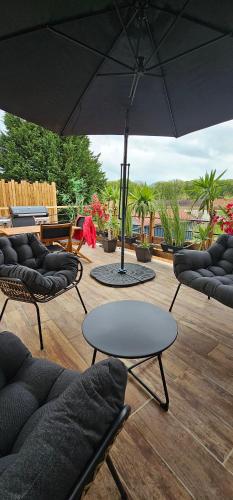 a patio with chairs and a table and an umbrella at Casa Bellissima Entièrement Climatisée in La Machine