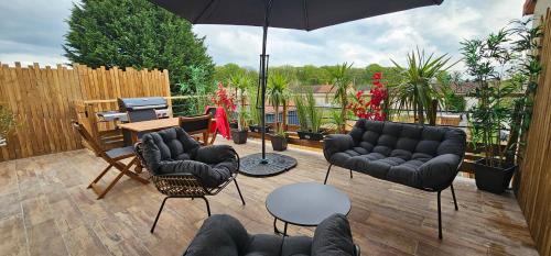 a patio with black furniture and an umbrella at Casa Bellissima Entièrement Climatisée in La Machine
