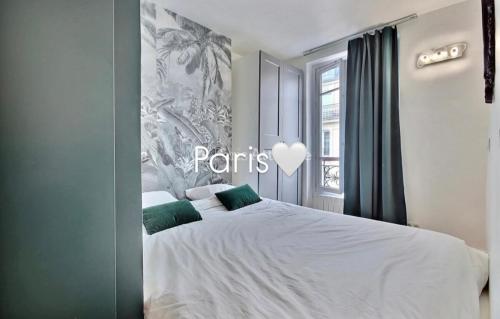 une chambre avec un grand lit blanc avec des oreillers verts dans l'établissement PARIS with Love !, à Paris