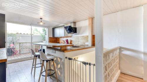 - une cuisine avec un comptoir et des tabourets dans l'établissement La Suite au Village, à Gruissan