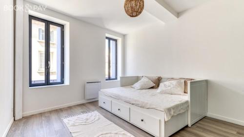 une chambre blanche avec un lit et deux fenêtres dans l'établissement La Suite au Village, à Gruissan