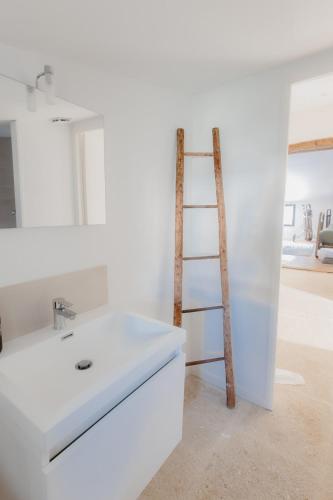 La salle de bains est pourvue d'un lavabo blanc et d'une échelle. dans l'établissement L'Oustal Di Fabre - Villa avec piscine à Vers-Pont-du-Gard, à Vers-Pont-du-Gard