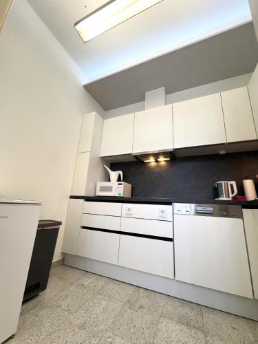 a white kitchen with white cabinets and appliances at Lavanttalbahn Suite in Mauterndorf