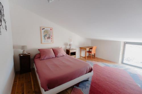 une chambre avec un lit, une table et une fenêtre dans l'établissement L'Oustal Di Fabre - Villa avec piscine à Vers-Pont-du-Gard, à Vers-Pont-du-Gard
