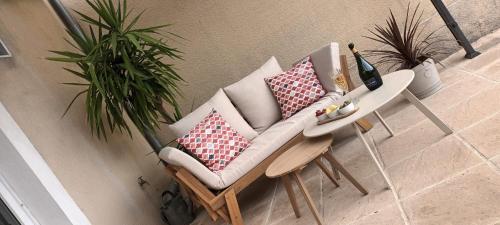 une chaise avec des oreillers à côté d'une table dans l'établissement Maison Bijou, à Loubès-Bernac