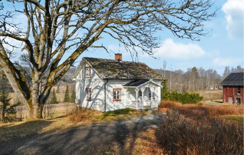 an old white house in a field with a tree at Nice Home In Årjäng With Wifi in Årjäng