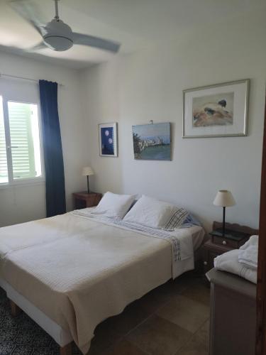 une chambre avec un lit et un ventilateur de plafond dans l'établissement Villa Erbella with sea view from balcony and lovely garden, à La Celle-sous-Gouzon