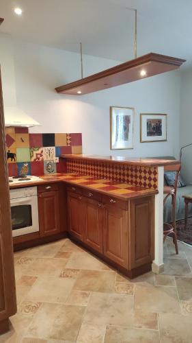 une cuisine avec des armoires en bois et un comptoir dans l'établissement Villa Erbella with sea view from balcony and lovely garden, à La Celle-sous-Gouzon