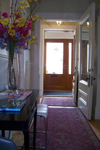 a hallway with a door and a vase of flowers at Auberge aux Deux Lions in Quebec City