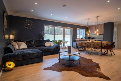a living room with a couch and a table at Reigi Holiday Home, Hiiumaa with Nordic HotTub & Sauna in Reigi