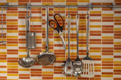 a group of kitchen utensils hanging on a wall at Impero 5 duepiuno in Acquaviva delle Fonti