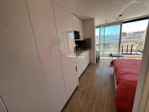- une chambre avec des placards blancs et un lit rouge dans l'établissement Studio 4 personnes Cap d'Agde Naturisme CN060-E30, au Cap d'Agde