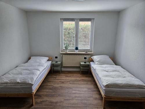 two beds in a room with a window at Fewo Kirch Jesar in Kirch Jesar