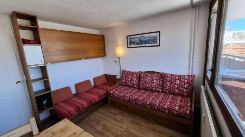 - un canapé rouge dans une chambre avec fenêtre dans l'établissement Résidence Le France - Studio 2 personnes Plagne Centre MAE-2804, à Aime La Plagne