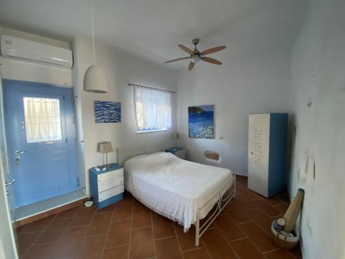 a bedroom with a bed and a ceiling fan at L' Atelier, Marpissa Paros in Márpissa