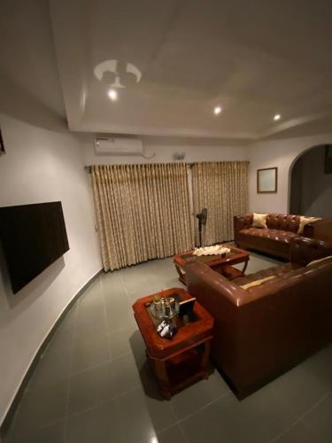 a living room with a couch and a table at Luxury Villa AC Ensuite Room 7 in Limbe