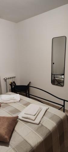 a bedroom with a bed with a mirror on the wall at Little Rose garden in Aci Catena
