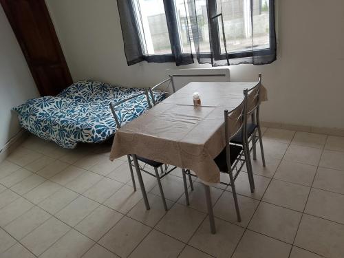 une table et des chaises dans une chambre avec un lit dans l'établissement Maisonnette, à Saintes