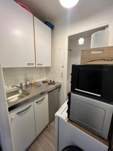 une petite cuisine avec un évier et un micro-ondes dans l'établissement Paris center cosy 2pax private flat, à Paris