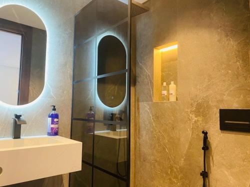 ein Badezimmer mit Dusche, Waschbecken und Spiegel in der Unterkunft spectrum studio in Casablanca