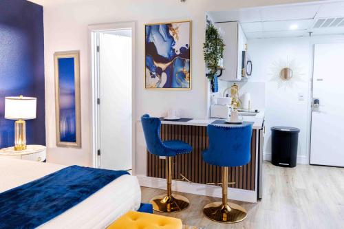 a bedroom with a bed and a kitchen with blue chairs at Luxury Lakeview Getaway 1 mile Universal Studios in Orlando
