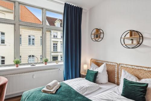 a bedroom with a bed and a large window at NEU Altstadtliebe - gemütliche Apartments in der historischen Altstadt, zentral und komfortabel in Wismar