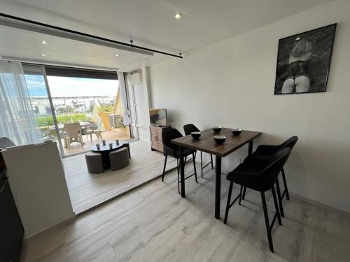 une salle à manger avec une table et des chaises noires dans l'établissement Studio 4 couchages CAP D'AGDE NATURISME CN060-E69, au Cap d'Agde