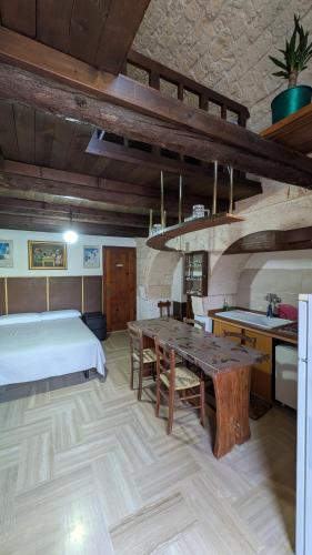 a bedroom with a bed and a table in a room at Trullo Malvisco in Alberobello