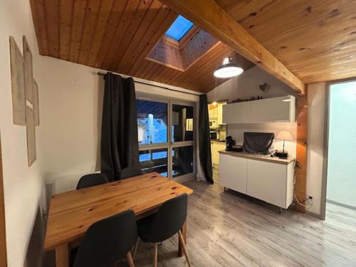 une cuisine et une salle à manger avec une table et des chaises en bois dans l'établissement Résidence Les Campanules - Les Campanules CA43FB MAE-0341, à Villarodin-Bourget