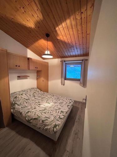 une chambre avec un lit avec un plafond en bois dans l'établissement Résidence Les Campanules - Les Campanules CA43FB MAE-0341, à Villarodin-Bourget