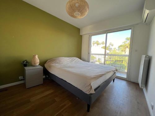 une chambre avec un lit et une grande fenêtre dans l'établissement ROSE DES VENTS, à Antibes