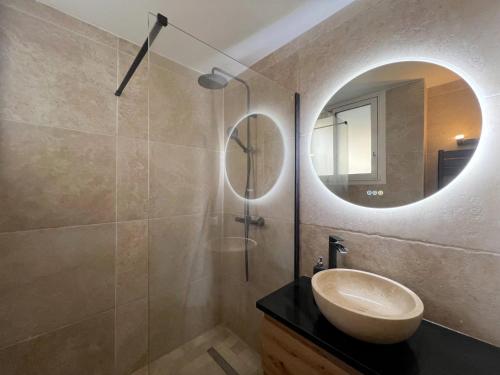 une salle de bain avec un lavabo et un miroir dans l'établissement ROSE DES VENTS, à Antibes