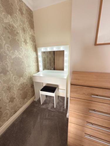 a bathroom with a white vanity and a mirror at Spacious 3 Bedroom House in Wool in Wool