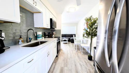 una cucina con armadi bianchi e lavandino di Sunny Shores Retreat 2 a Clearwater Beach