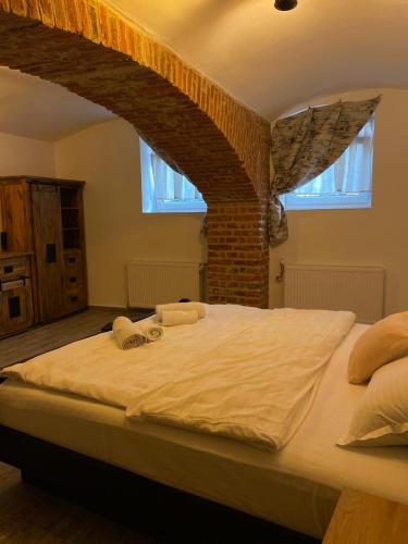 a bedroom with a large bed with two towels on it at Liberte Apartments in Oradea
