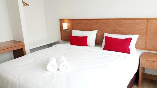 a bedroom with a white bed with red pillows at Donchan Residence in Chiang Mai