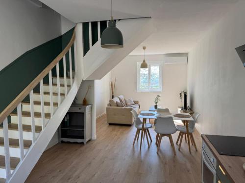 - un salon avec un escalier, une table et des chaises dans l'établissement T3 duplex village house, à Ville-sous-Anjou