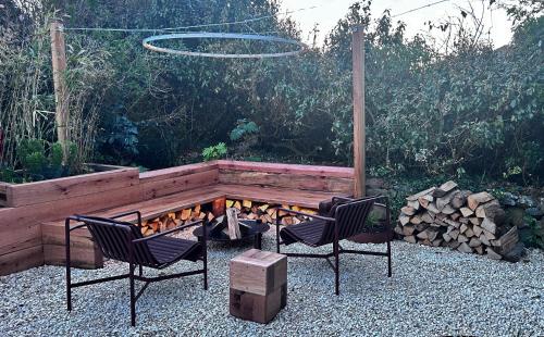 a backyard with two chairs and a fire pit at Howlyek, in St Agnes Village in St. Agnes