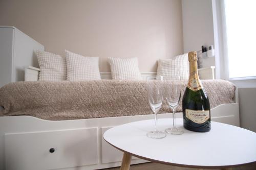 - une bouteille de champagne et 2 verres à vin sur une table dans l'établissement Studio hyper centre secteur Cathedrale - Forum- Erlon, à Reims