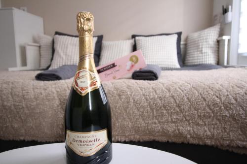 - une bouteille de champagne assise sur une table devant un lit dans l'établissement Studio hyper centre secteur Cathedrale - Forum- Erlon, à Reims