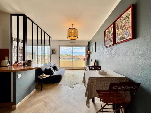 un salon avec une table et un canapé dans l'établissement Studio Cozy - Balcon - Centre-Ville, à Six-Fours-les-Plages