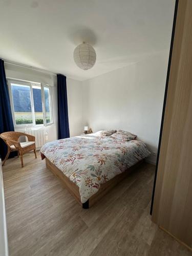 une chambre avec un lit, une chaise et une fenêtre dans l'établissement Maison face à la mer, à Saint-Marcouf