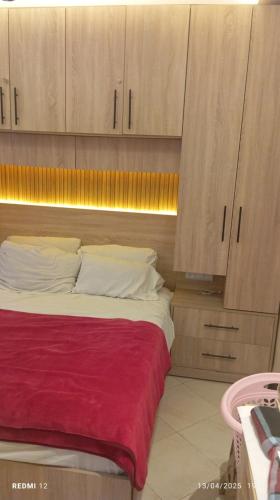 a bed in a room with wooden cabinets at Appart Family Agadir Maskani lhouda in Agadir
