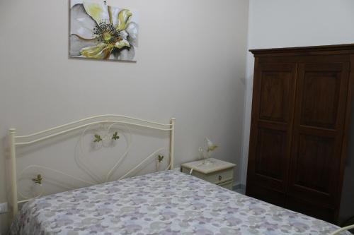 a bedroom with a bed with a flower picture on the wall at casa blu in SantʼAndrea